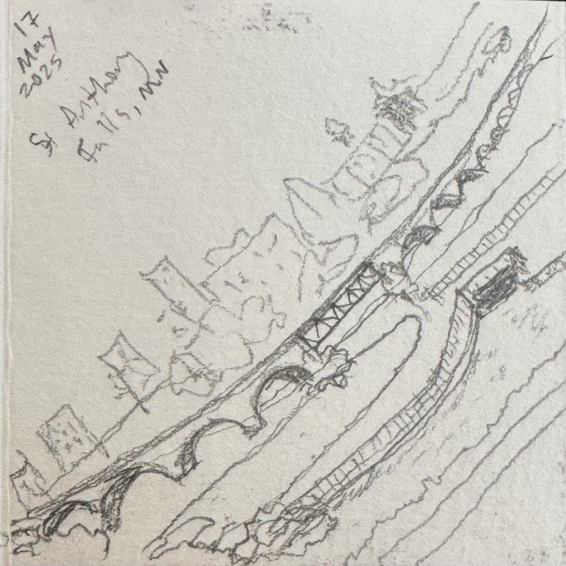 A sketch portrays a bridge and surrounding landscape with handwritten notes indicating the location and date: St Anthony Falls, MN, 17 May 2025. This is from my 2”x2” pocket sketchbook. 