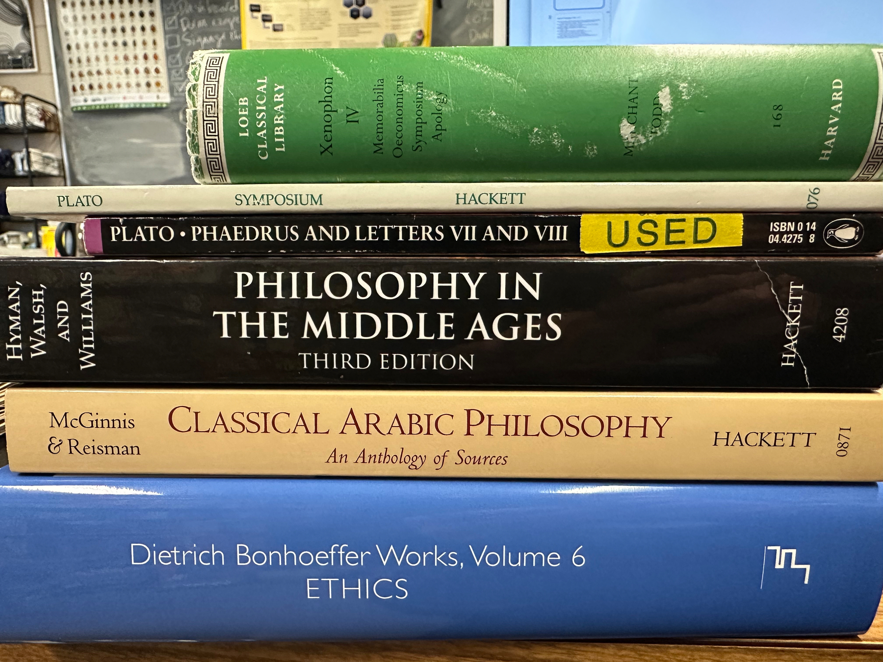 A stack of philosophy books, including titles on Plato, medieval philosophy, classical Arabic philosophy, and Dietrich Bonhoeffer.
