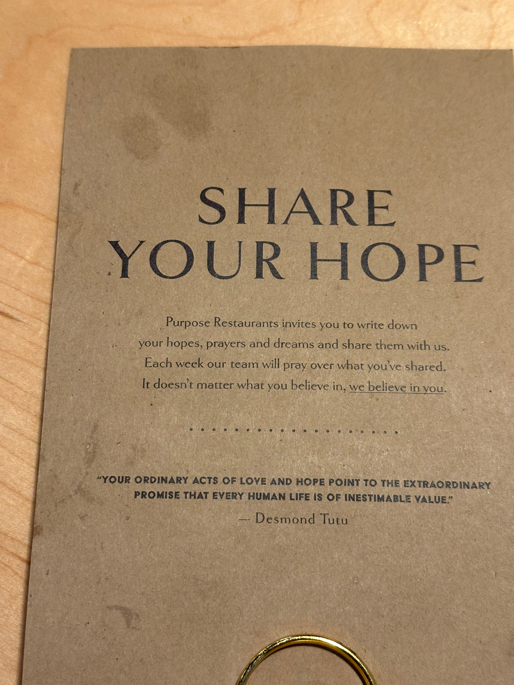 A beige poster encourages people to write down and share their hopes, dreams, and prayers, including a quote by Desmond Tutu.