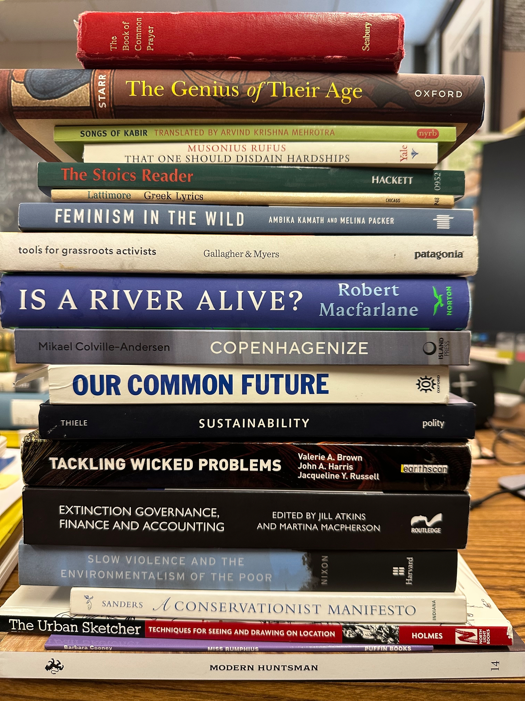 A stack of various books on topics including environmental issues, sustainability, urban development, and art.