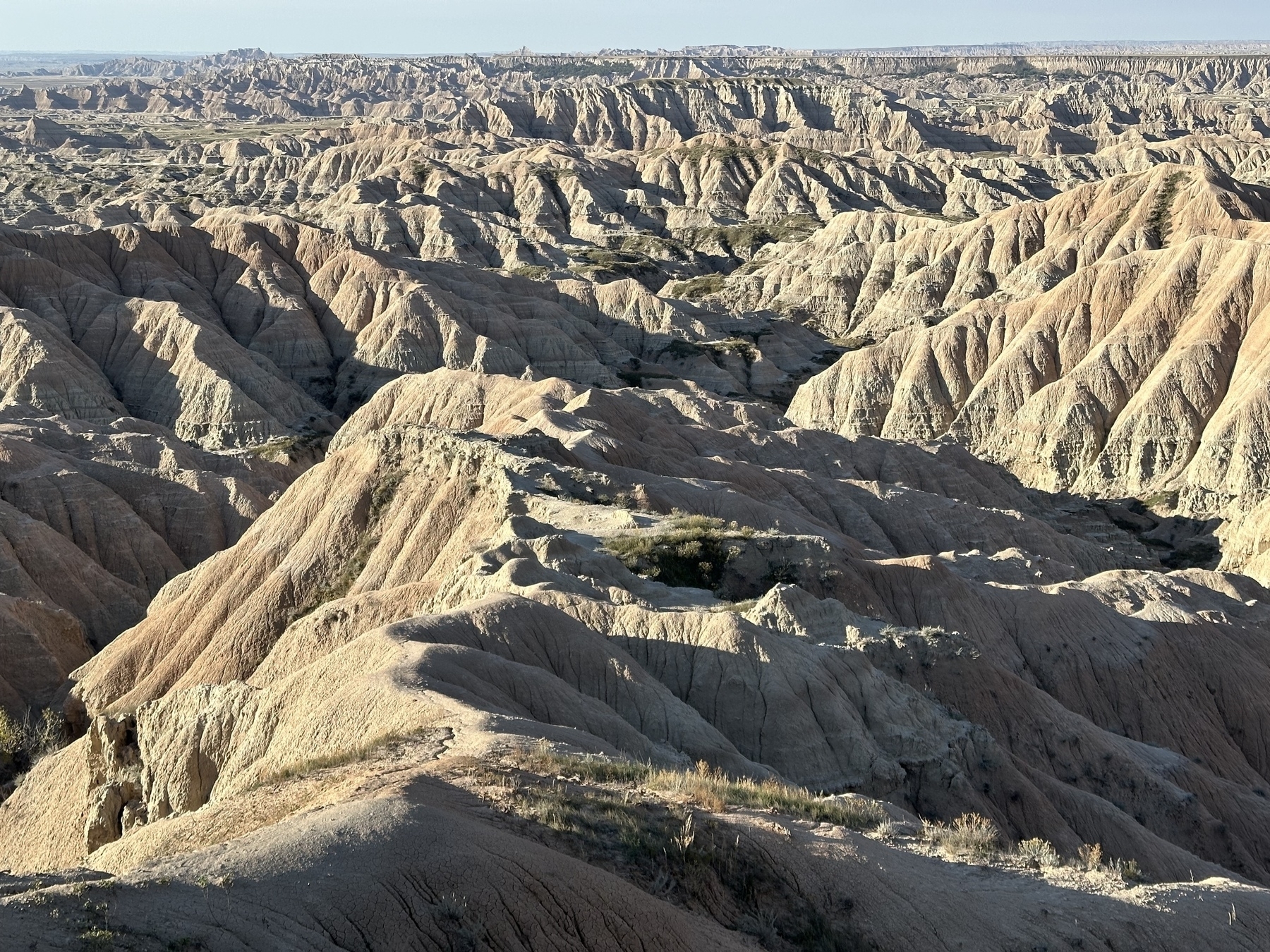A vast landscape of rugged, eroded rock formations stretches into the distance.
