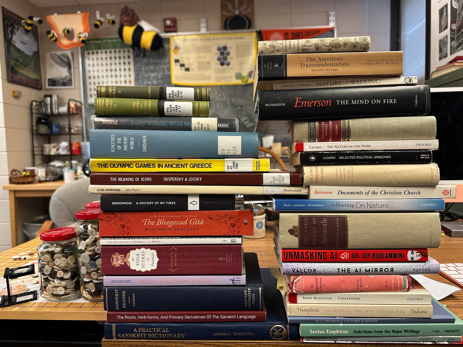 Two stacks of books in philosophy and religion on a desk.
