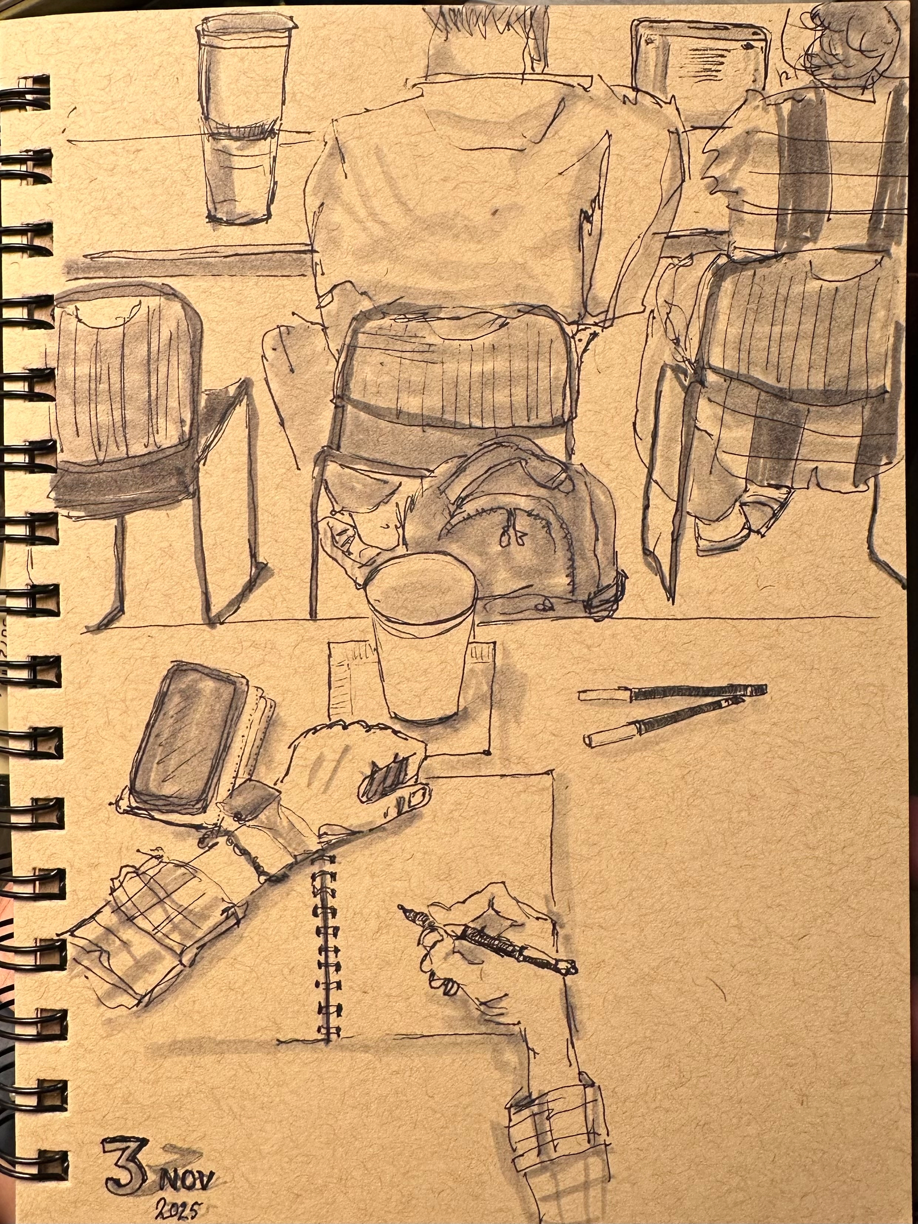 A sketch depicts people seated from behind at a table, with notebooks, a coffee cup, and a hand writing in a notebook. 