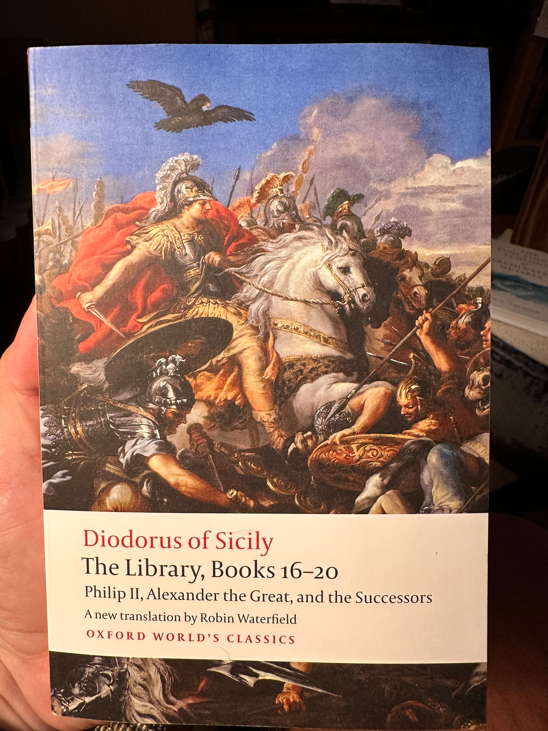 A historical painting depicting a battle scene with warriors in armor, horses, and an eagle flying above is featured on the cover of a book titled Diodorus of Sicily: The Library, Books 16-20, focusing on Philip II, Alexander the Great, and their successors.