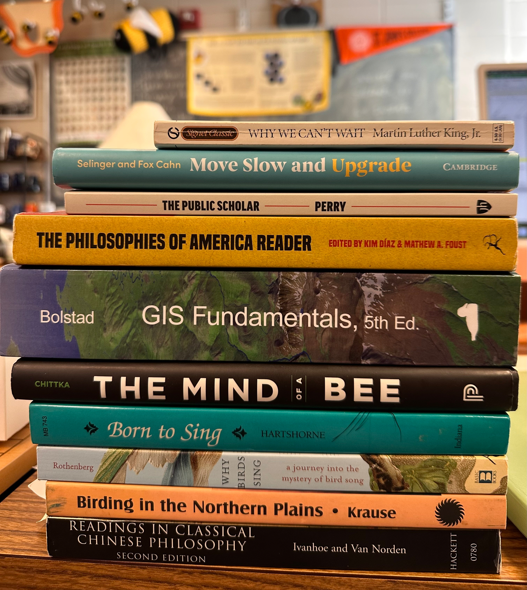 A stack of nine books includes titles on technology, philosophy, bees, and birding, with WHY WE CAN'T WAIT by Martin Luther King, Jr. on top.