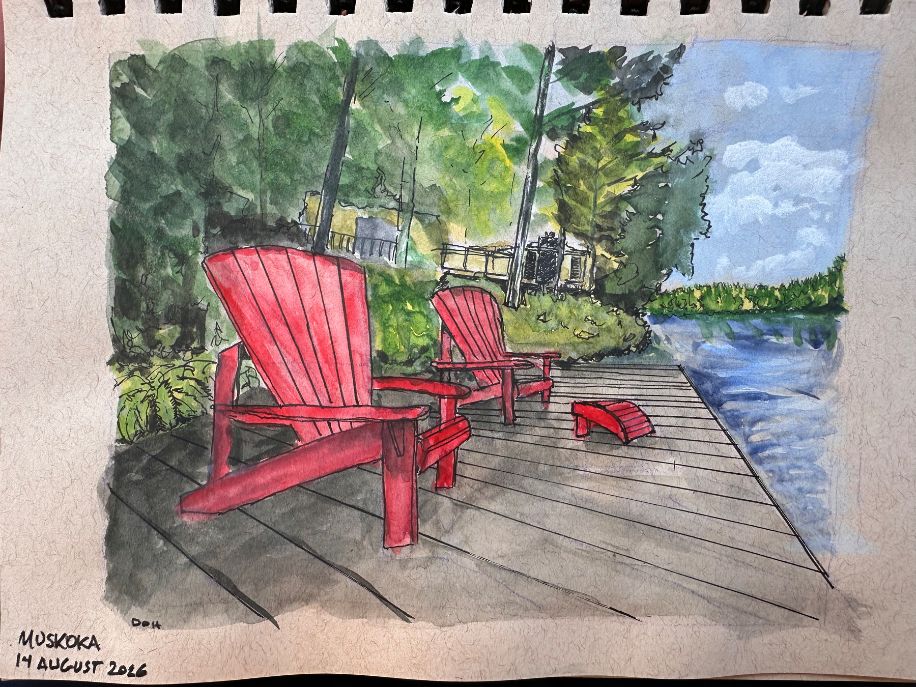 Two red Adirondack chairs and a matching footrest sit on a wooden dock by a lake, surrounded by trees and under a partly cloudy sky.