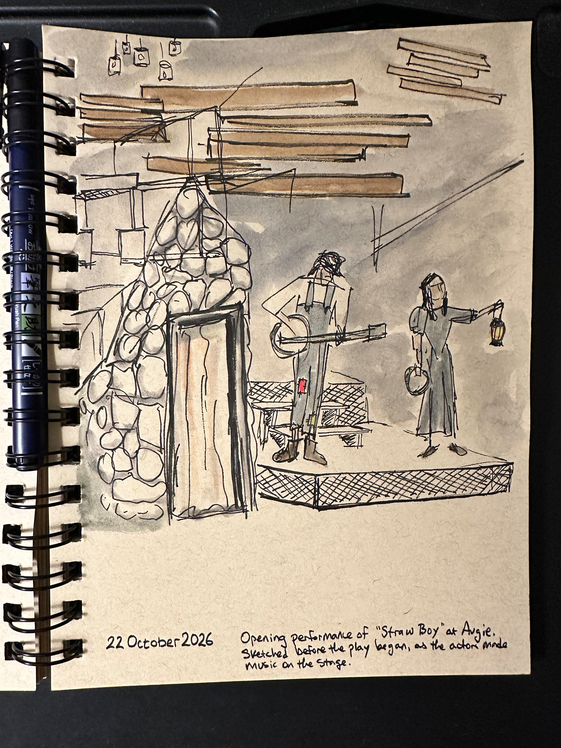 A sketch depicts a rustic stone fireplace with two figures nearby, one playing a banjo and the other holding a tambourine and a lantern, set on a small stage with wooden beams above.