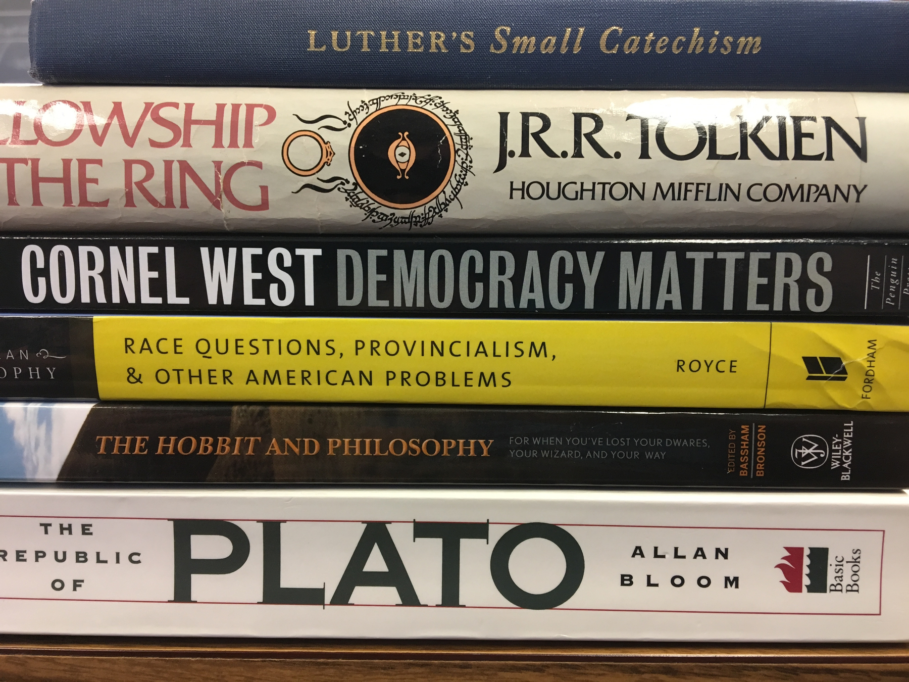 A collection of books on philosophy, literature, and social issues, including titles by J.R.R. Tolkien, Martin Luther, Josiah Royce, Cornel West, and Plato.