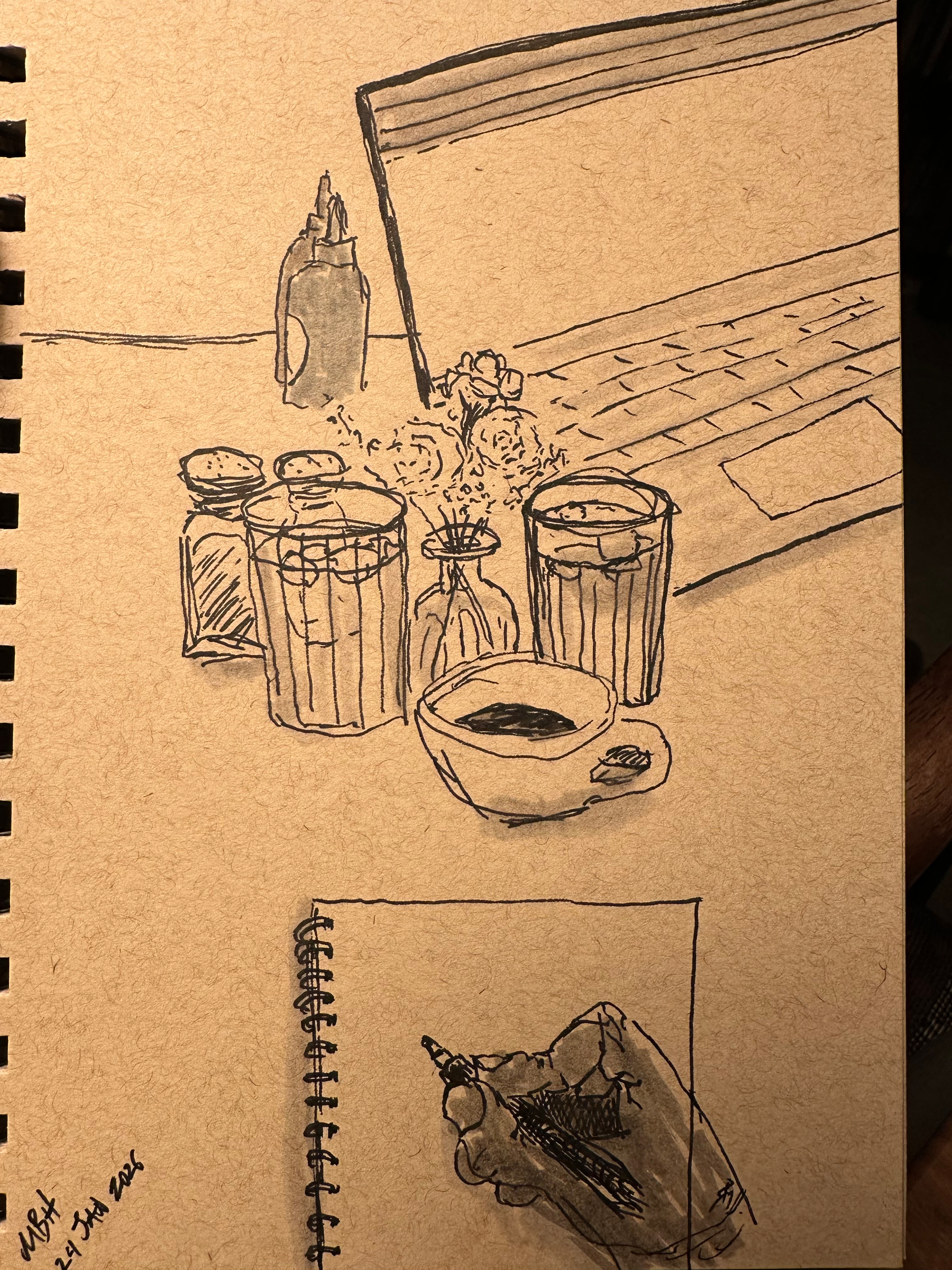 A sketch on a notepad depicts a laptop, jars, a small bowl, and a hand drawing on another notepad.