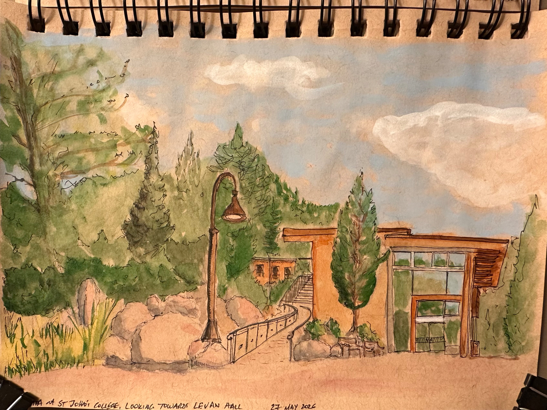 A watercolor sketch depicts a scenic view of Levan Hall at St. John's College, surrounded by trees and a lamppost.